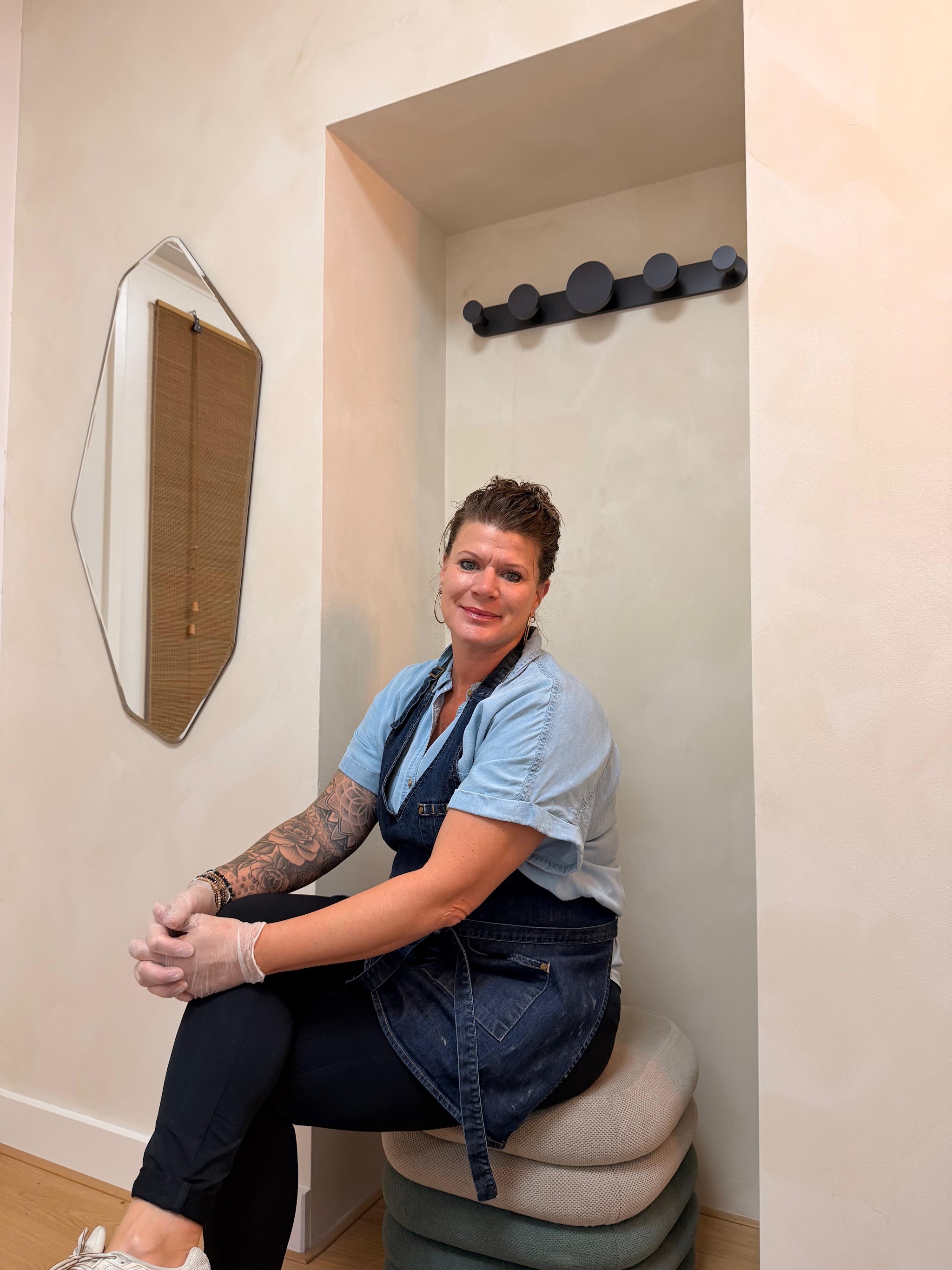 Anneke in de nis van haar studio, in blauw shirt en schort